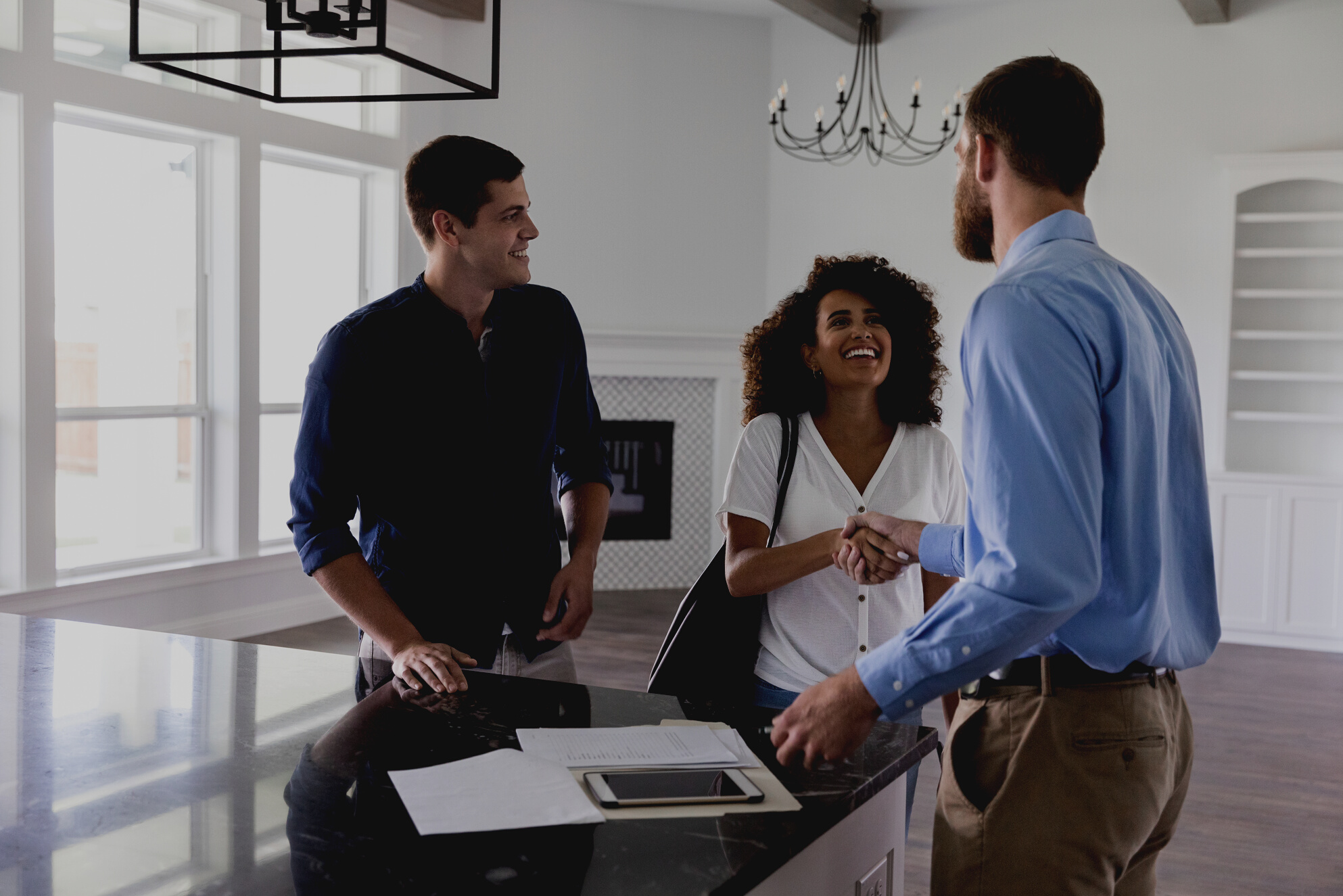 Young couple greet male realtor
